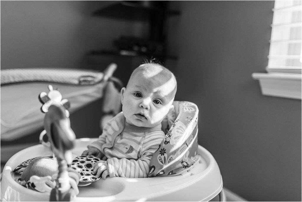 black and white photo of a baby in a walker