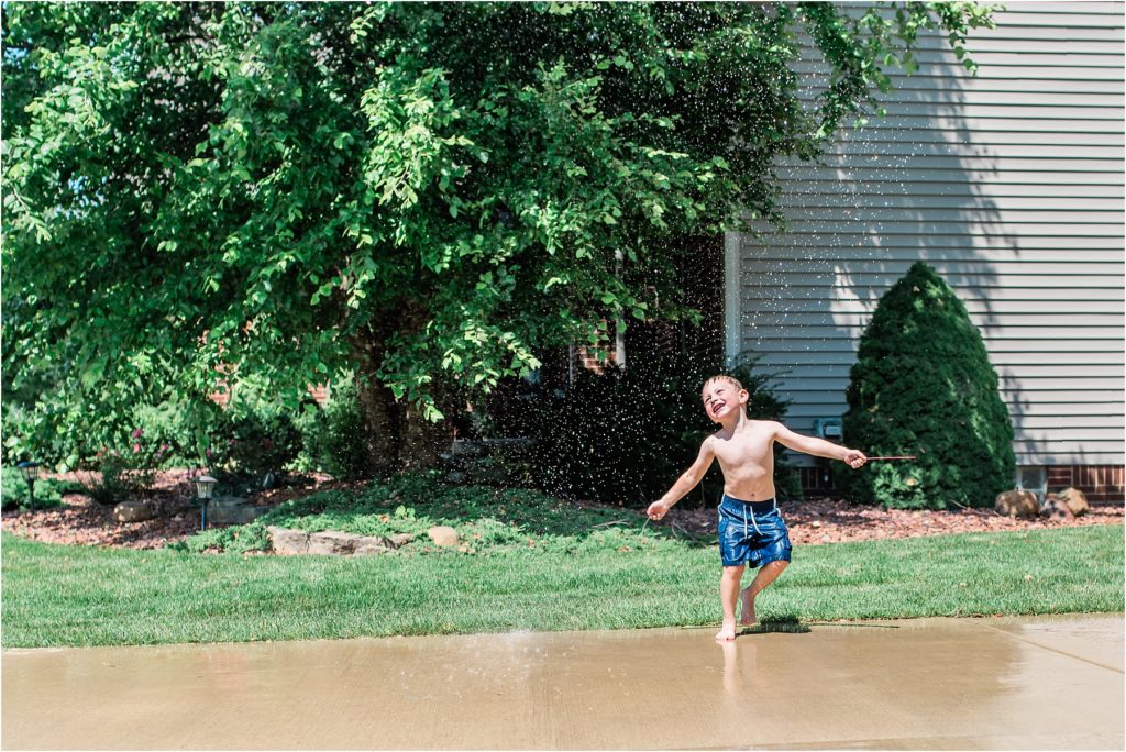 kid dancing in a sprinkler