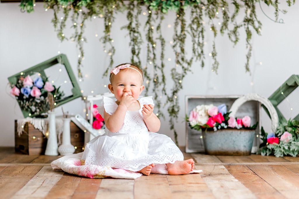 Baby in front of a floral backdrop.
