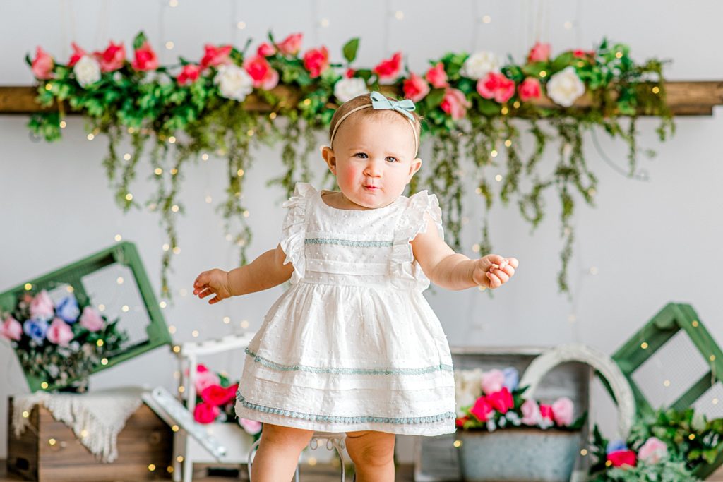 Baby in front of a beautiful floral backdrop.