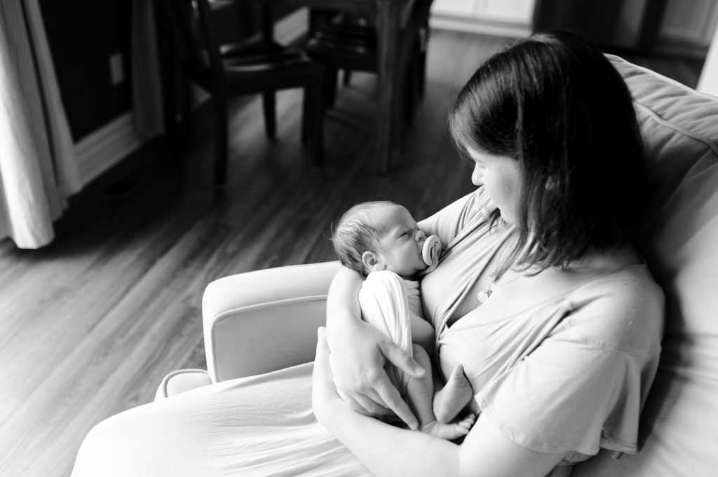 lifestyle newborn photo, mom cradling baby in black and white
