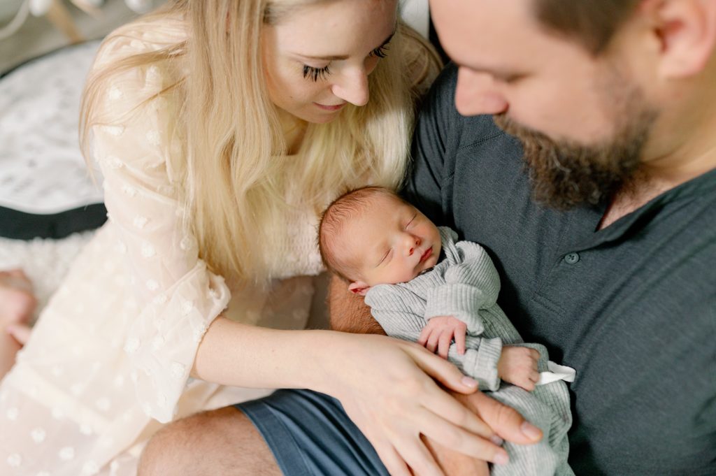 lifestyle newborn photo: mom and dad snuggling baby