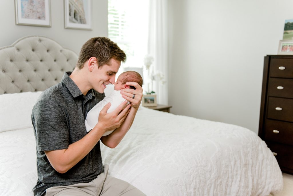 Dad touching nose to nose with newborn baby