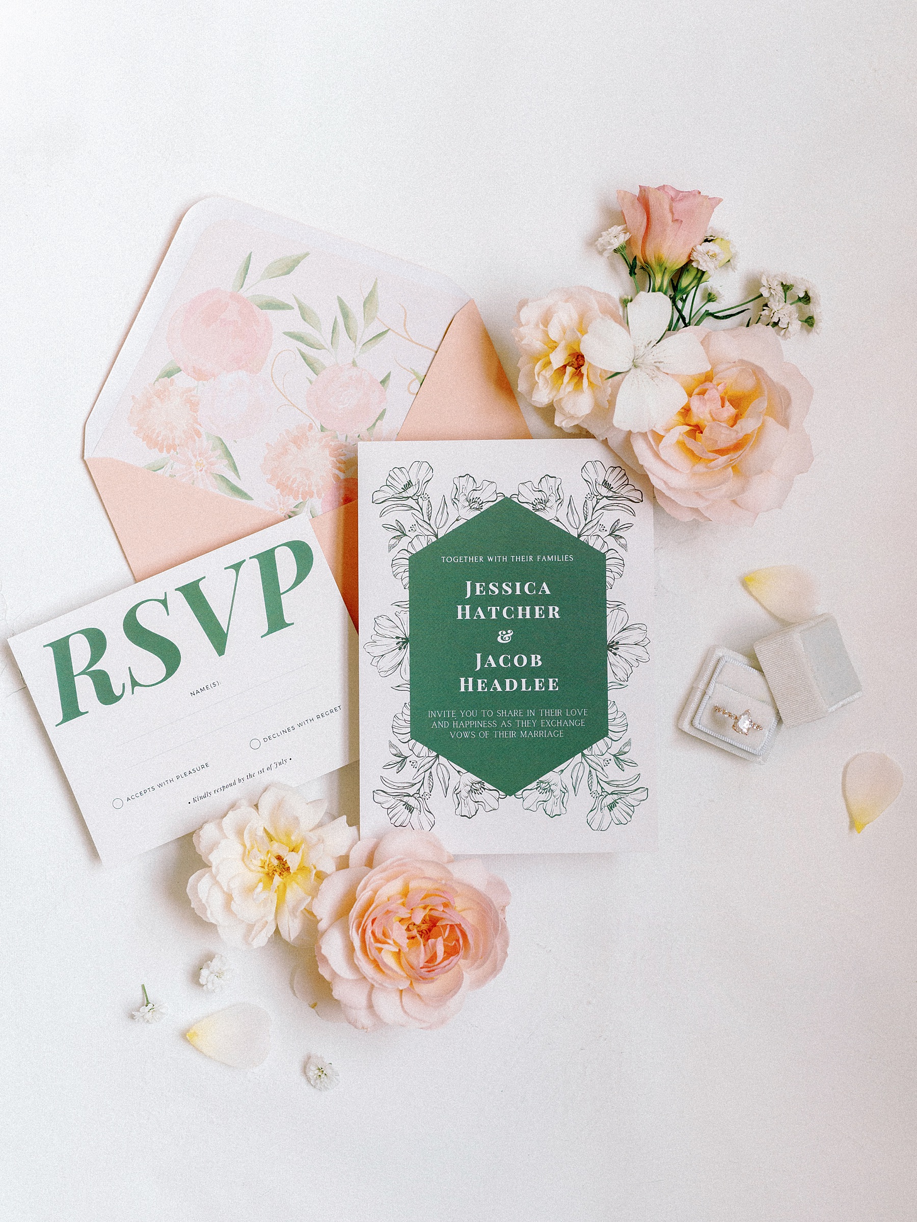 Flat lay photo of an invitation suite for a wedding in Grand Rapids, MI. Surrounded by pretty florals and the bride's ring.