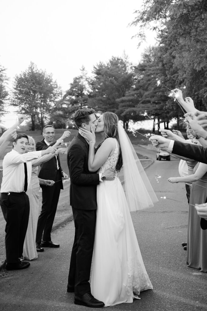 Bride and Groom kissing during a sparkler exit on their wedding day.