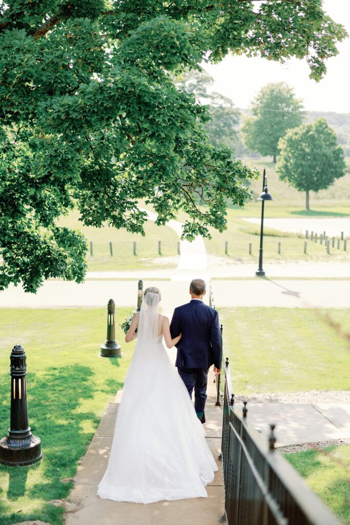 Bride and her dad walking toward the chapel for her wedding together