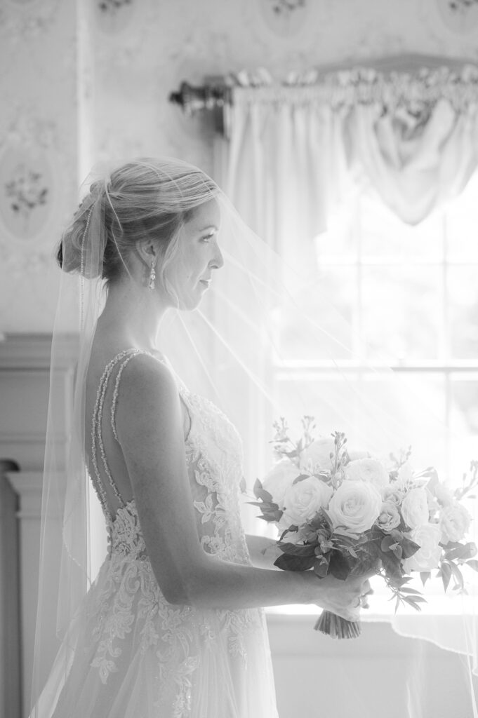 Side profile of a bride with her bouquet and veil over her face