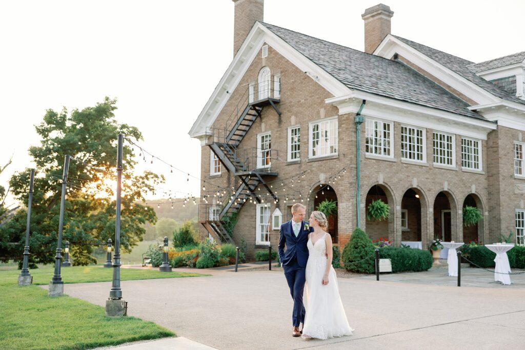 Bride and groom walking in front of the felt mansion on their wedding day