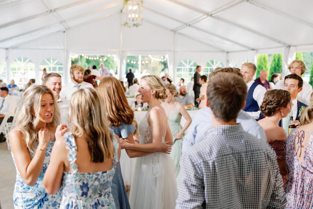 bride laughing with her guests while dancing at her reception at the felt mansion