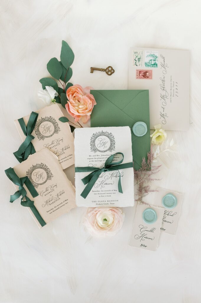 Green and white wedding stationary styled with peach and aqua accents in a beautiful flat lay photo
