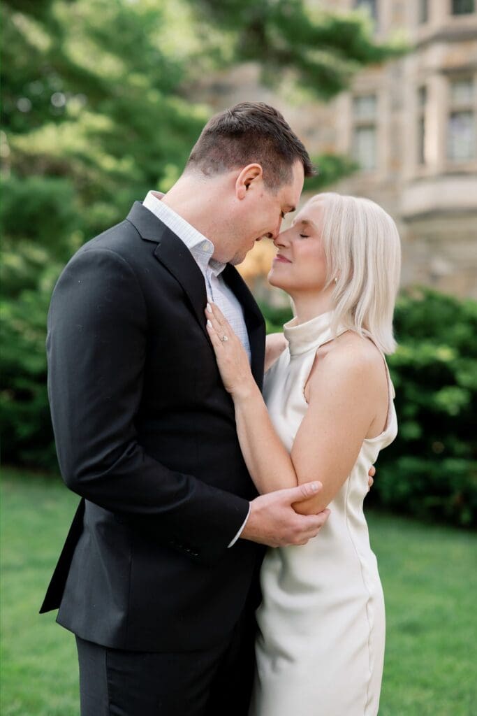 A couple embracing forehead to forehead at the Law Quad
