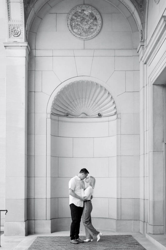A couple embracing inside a carved stone archway at the Law Quad, Ann Arbor engagement session