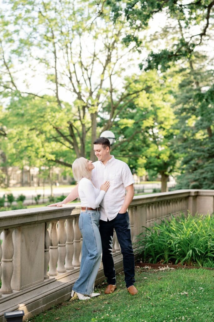 A couple leaning together against a stone balustrade at the Law Quad